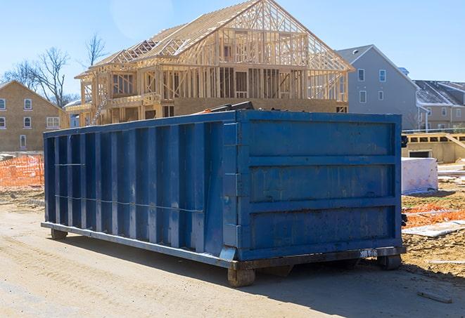 large, green residential dumpsters situated at an outdoor event